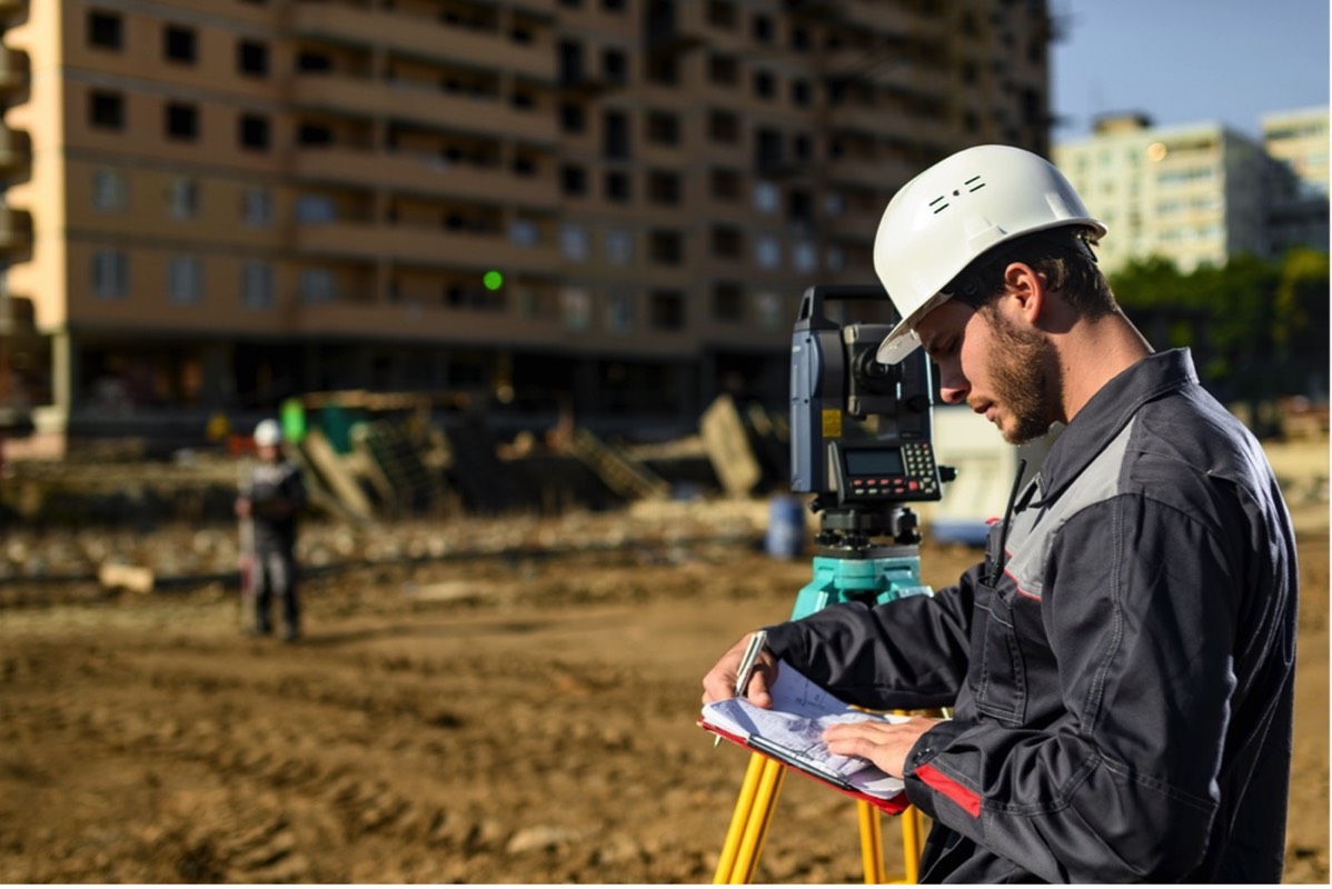 land surveyor on plot close to tall London building